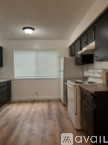 A kitchen with wooden floors and white walls.
