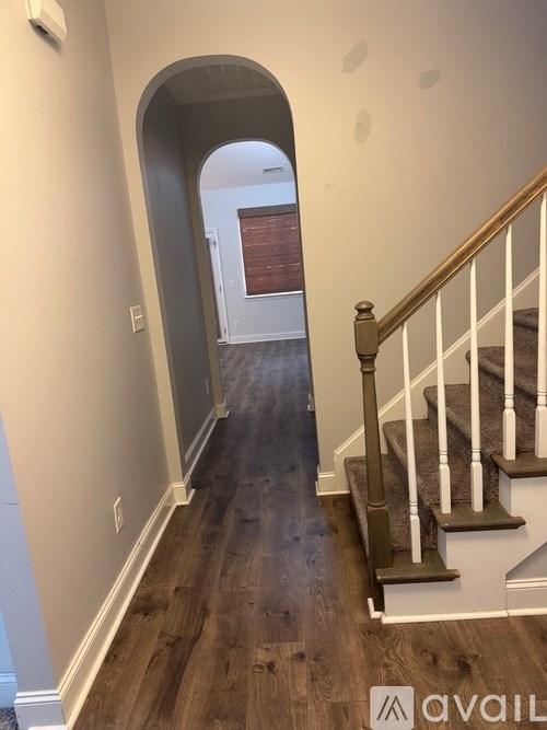 A hallway with a staircase and a window.