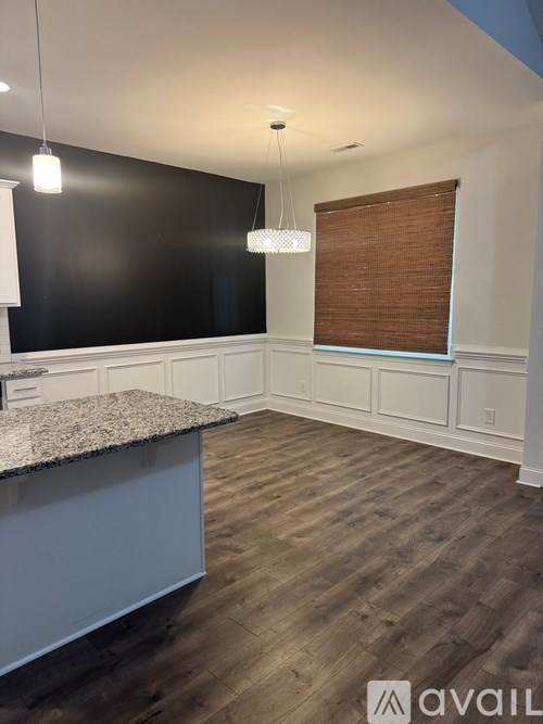 A kitchen with a granite countertop and wooden flooring.