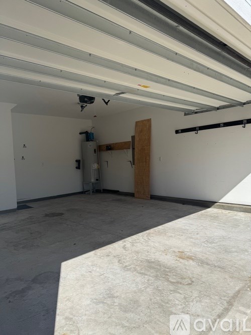 A large empty room with a door in the middle and a wall-mounted security camera.