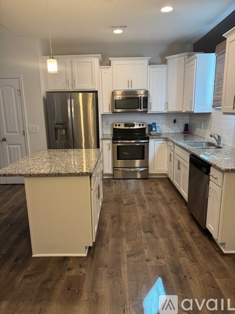 A kitchen with a granite countertop and stainless steel appliances.