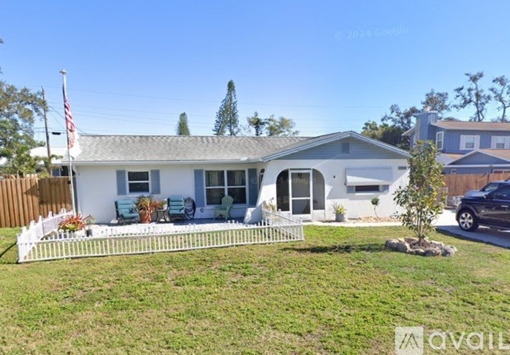 A house with a white picket fence is for sale.