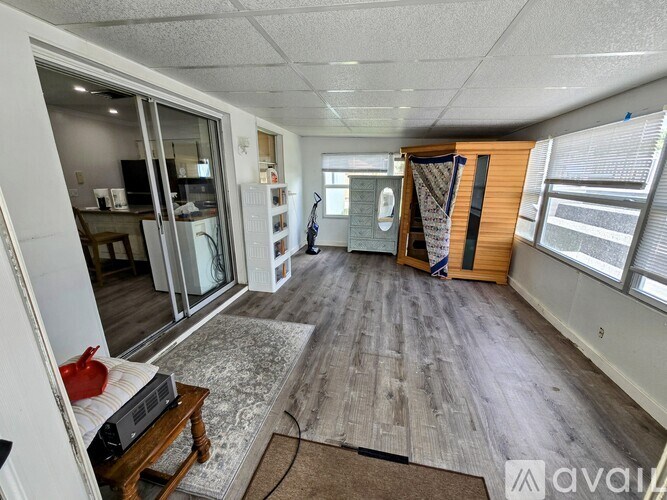 A room with wooden flooring and a sliding glass door leading to a balcony.