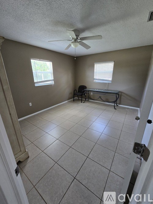 A room with a ceiling fan and a window.