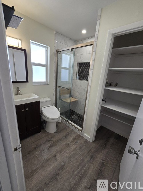 A bathroom with a toilet, sink, and walk-in shower.