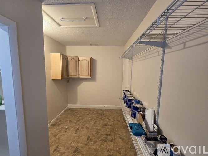 A storage room with a white shelving unit and a carpeted floor.