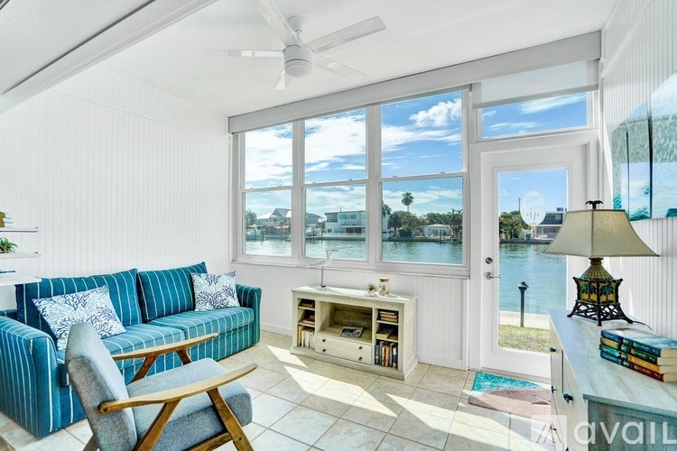 A living room with a blue couch and a fan.