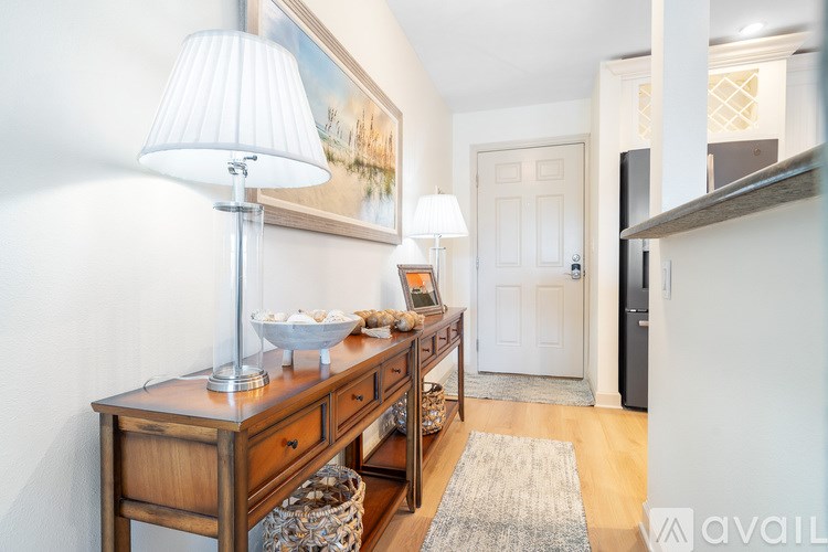 A kitchen with a black fridge and stove top oven.