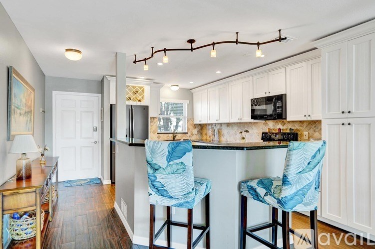A kitchen with a white counter and blue chairs.