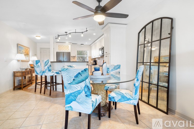 A living room with a black leather couch, a chair, and a television.