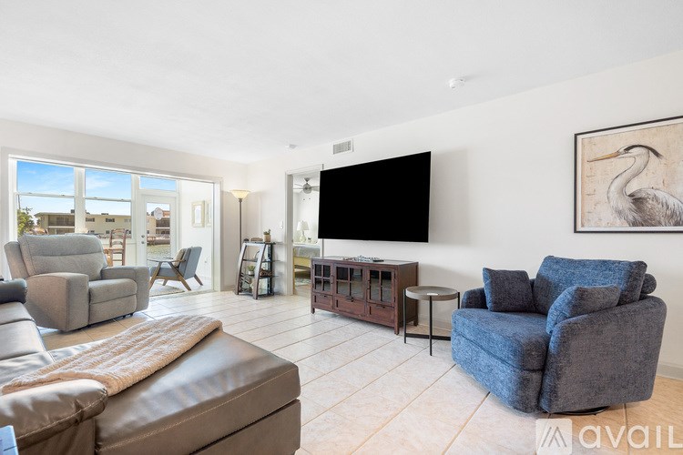A living room with a brown leather couch and a flat screen TV.