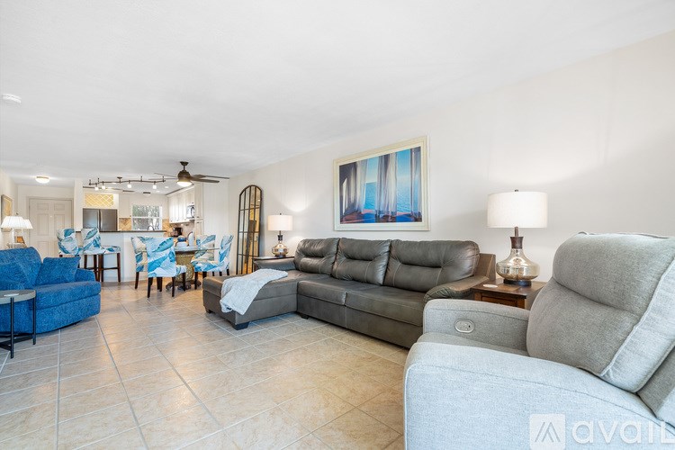 A living room with a blue couch and a wooden chair.
