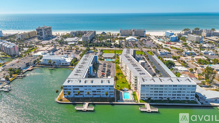 A body of water with buildings in the background and a clear blue sky.