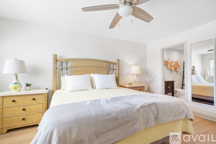 A bathroom with a toilet, a shelf with toiletries, and a shower with a glass door.