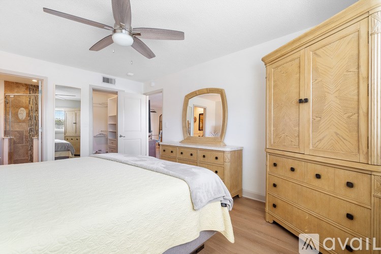 A bathroom with a white sink and brown cabinetry.