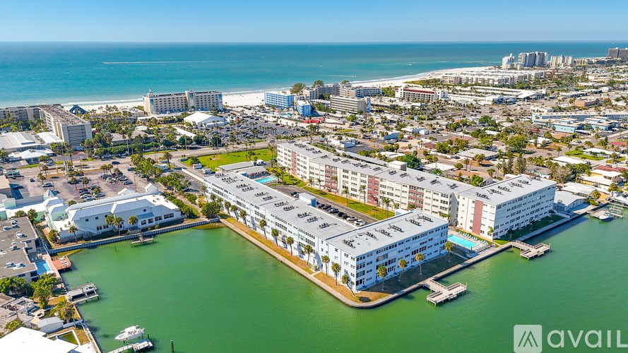 A swimming pool surrounded by palm trees and lounge chairs.