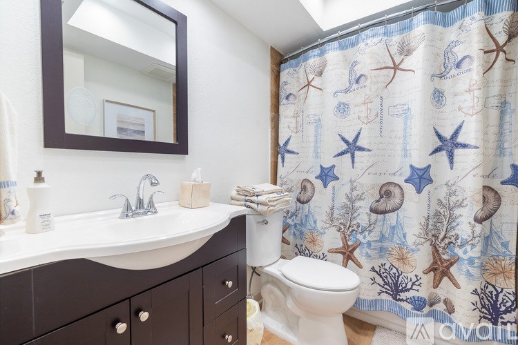 A living room with a television, a chair, and a ceiling fan.