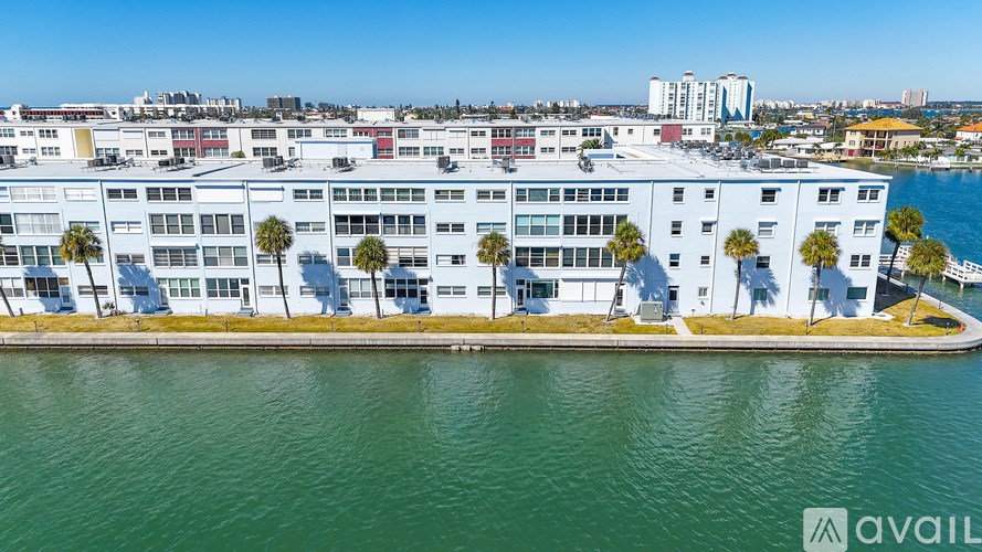 A living room with a tan couch, a ceiling fan, and a television.
