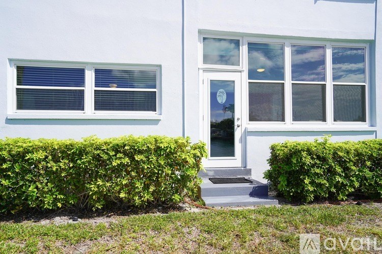A white house with a grey door and windows.