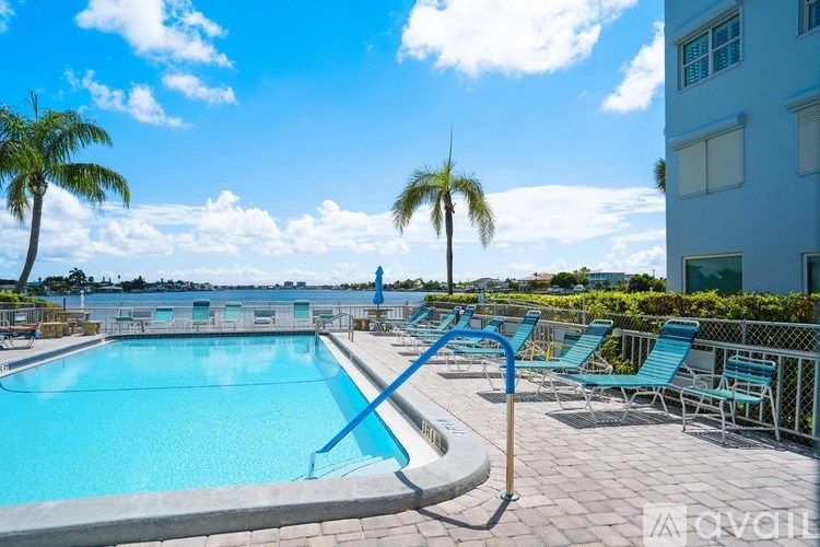 A swimming pool with a diving board and lounge chairs.