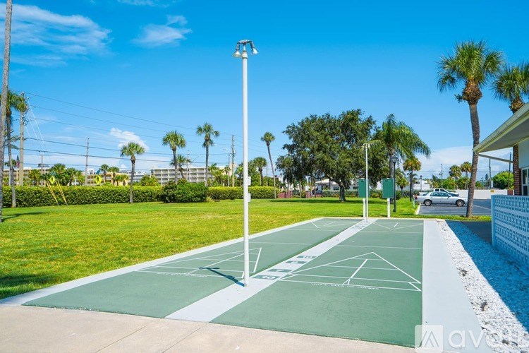 A tennis court with a white line in the middle and a green border.