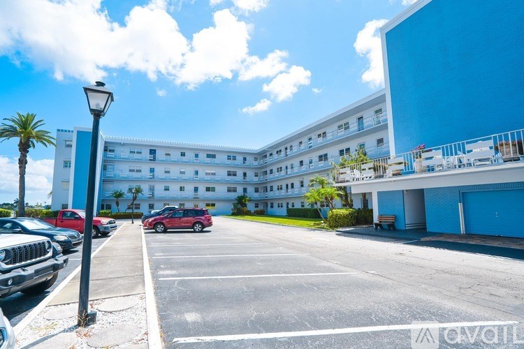 A parking lot with cars and a building in the background.
