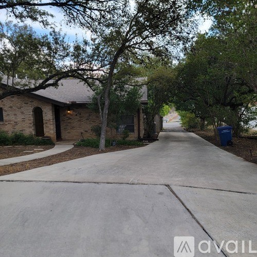 A residential street with houses on both sides and a tree-lined sidewalk.