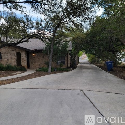 A residential street with houses on both sides and a tree-lined sidewalk.