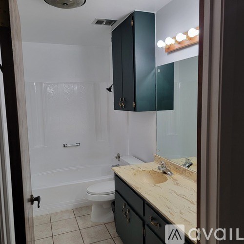 A bathroom with a toilet, sink, and mirror.