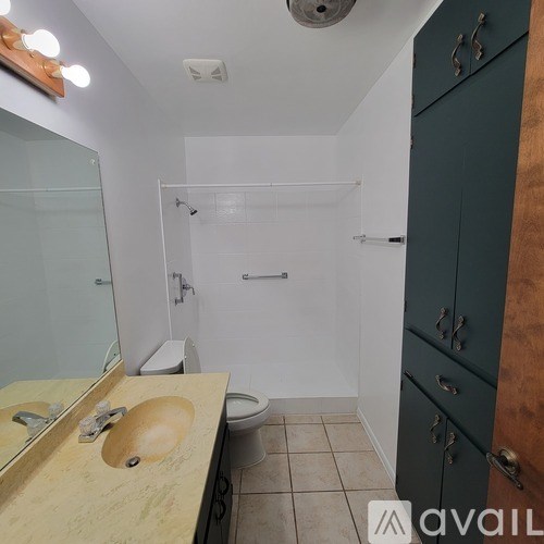 A bathroom with a sink, toilet, and shower.