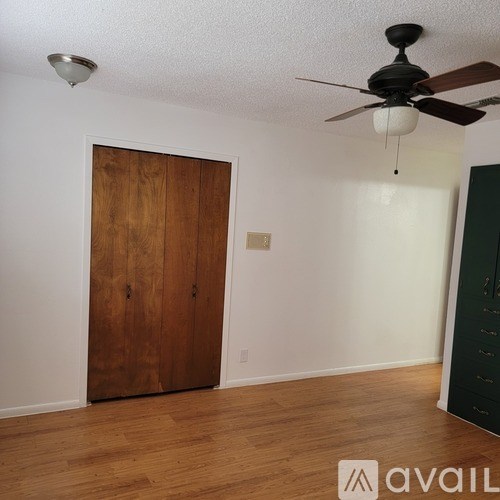 A room with a wooden door and a ceiling fan.