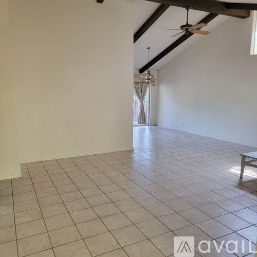 A room with a ceiling fan and tiled flooring.