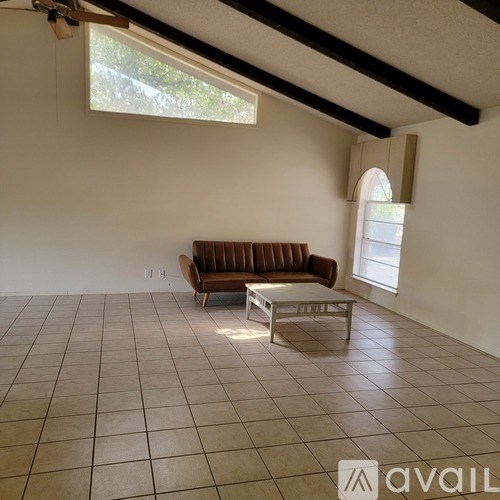 A living room with a brown couch and a white coffee table.