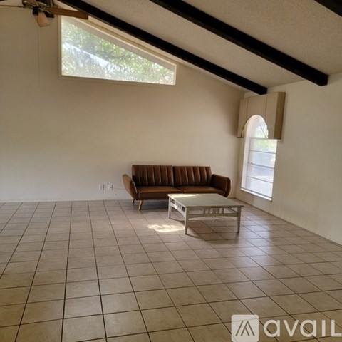 A living room with a brown couch and a white coffee table.