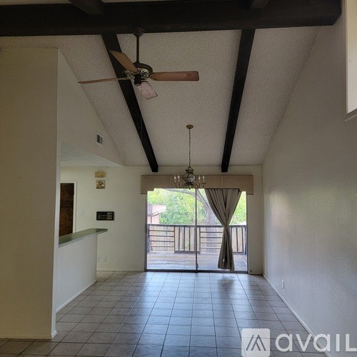 A room with a ceiling fan and a chandelier.