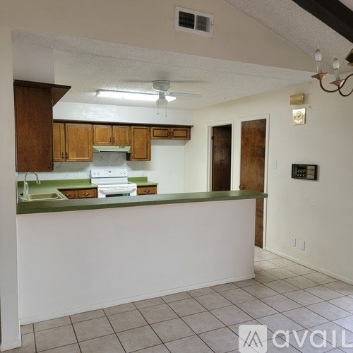 A kitchen with white walls and a green counter.