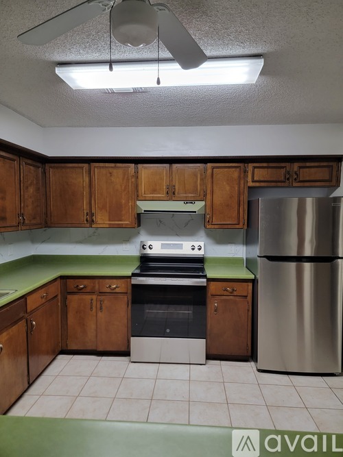 A kitchen with wooden cabinets and a green countertop.