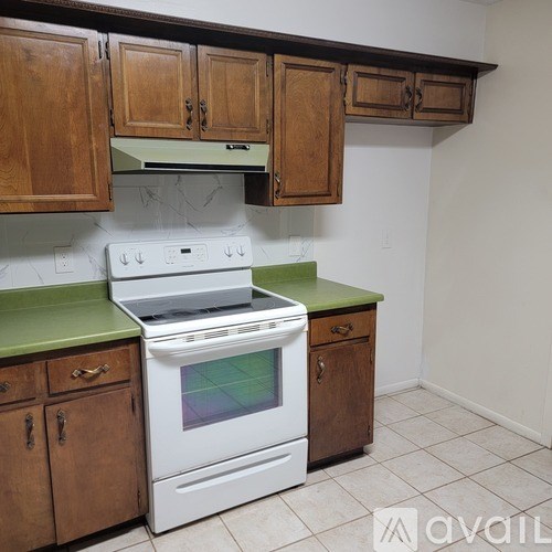 A white stove and oven in a kitchen with wooden cabinets.