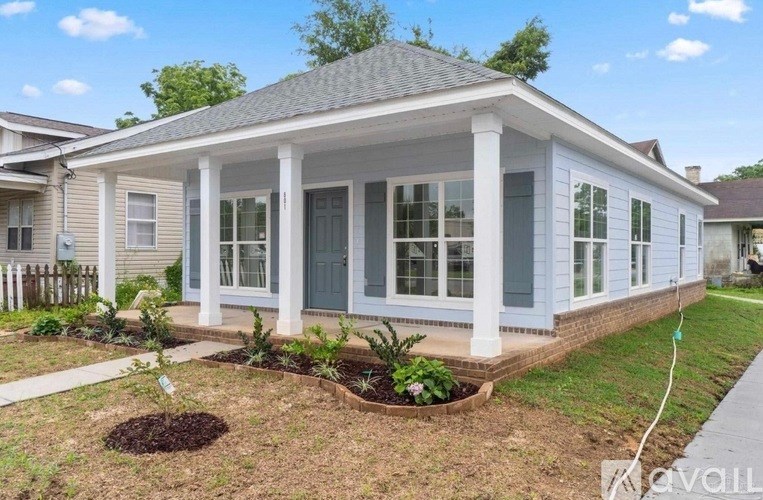 A small house with a front yard and a small garden.