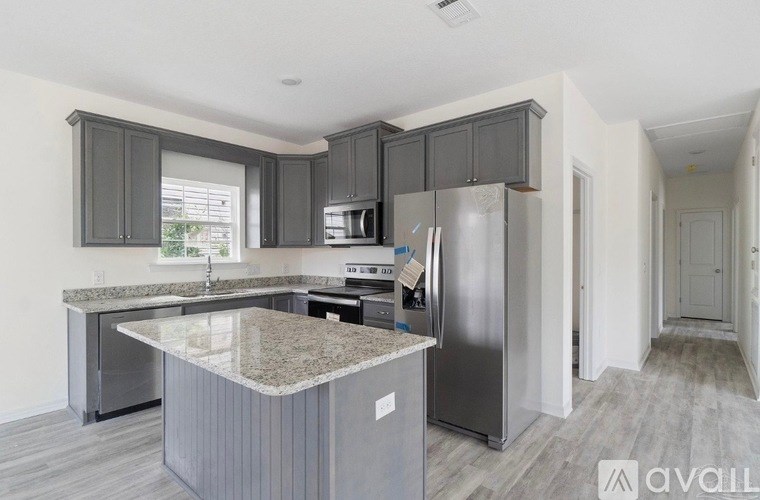 A kitchen with a granite countertop and stainless steel appliances.