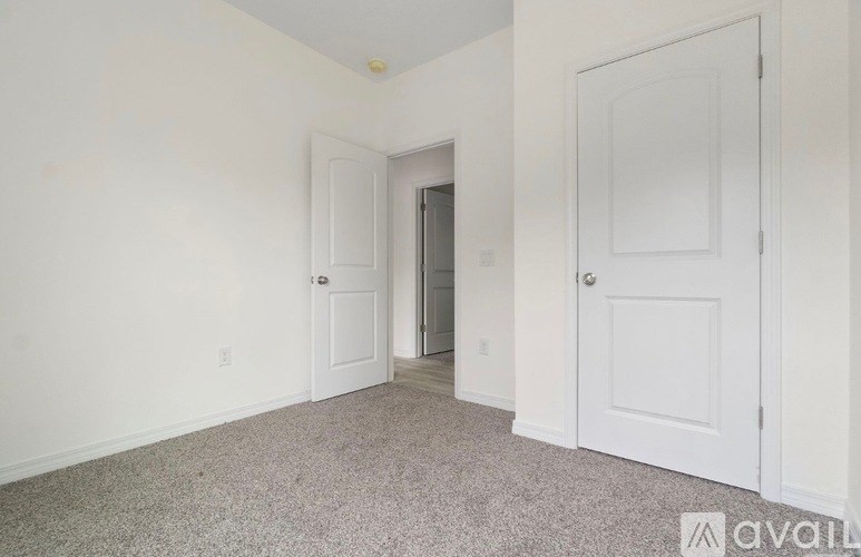 A room with two doors and a carpeted floor.