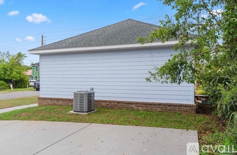 A house with a grey roof and a white wall with a window.