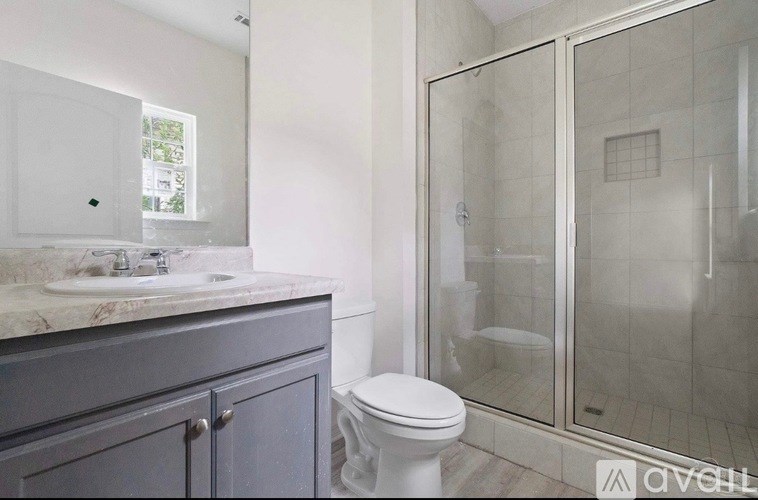 A bathroom with a toilet, sink, and shower.