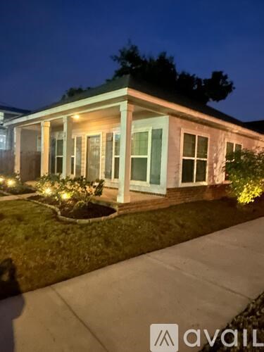 A house with a well-lit front porch and a small garden.
