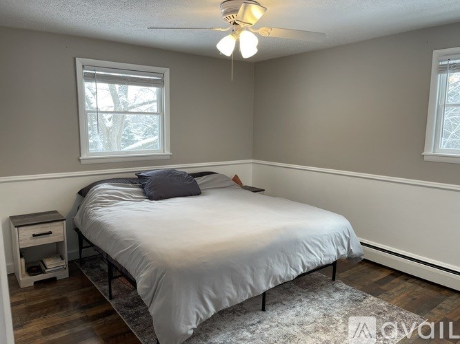 A bedroom with a bed, nightstand, and window.