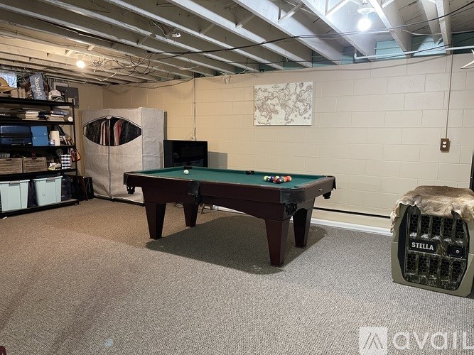 A room with a pool table and a Stella air conditioner.
