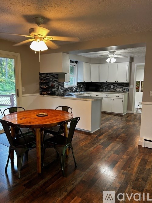 A kitchen with a table and chairs in the foreground.