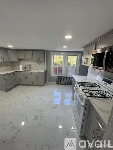 A kitchen with a marble floor and a stove top oven.