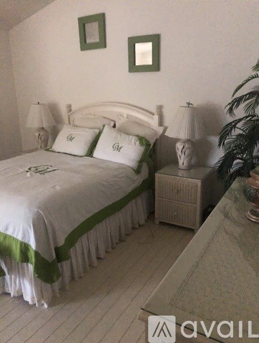 A bedroom with a bed, nightstand, and lamp.