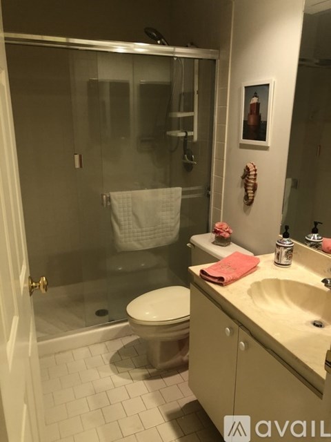 A bathroom with a toilet, sink, and shower.